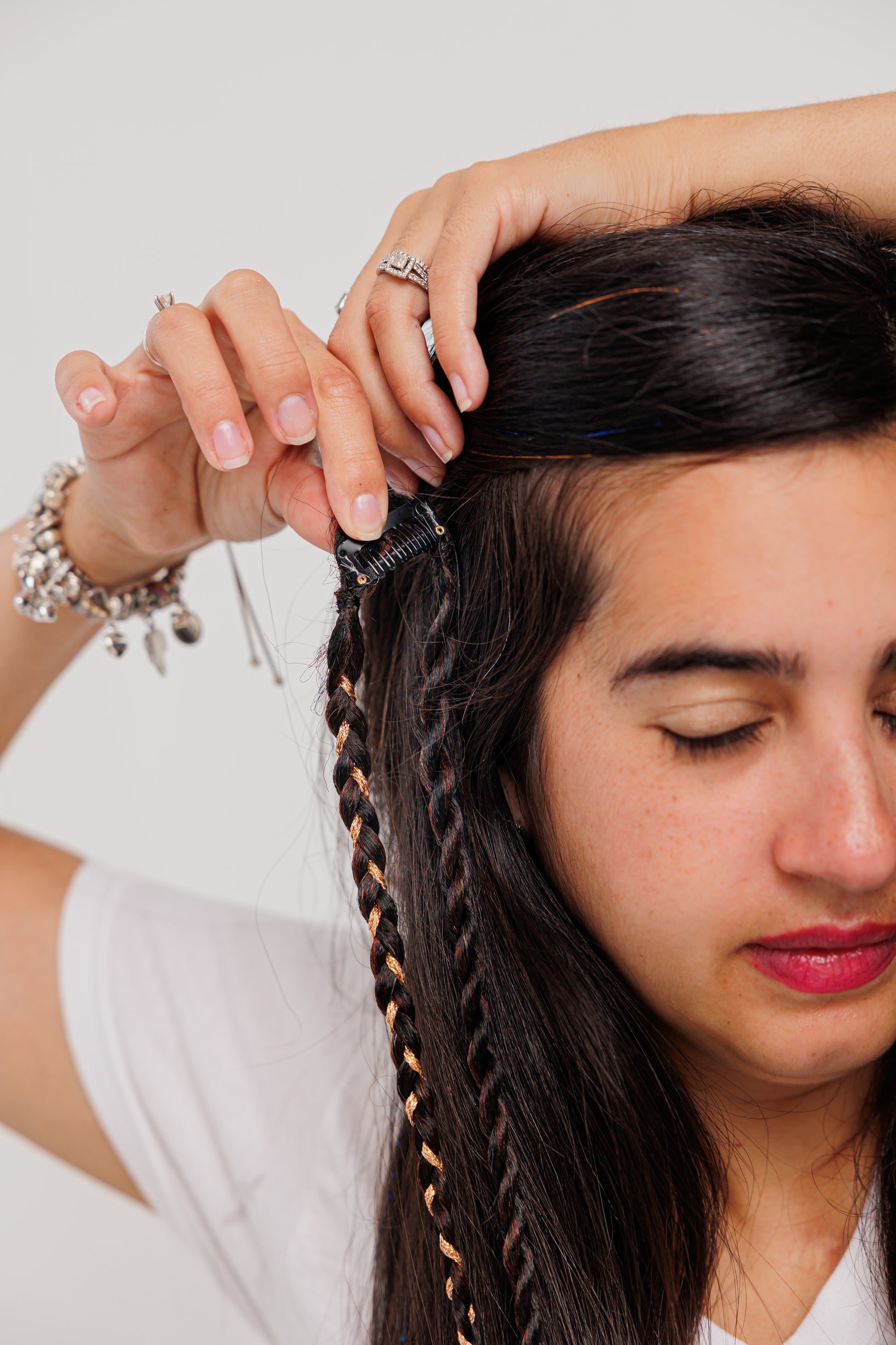 Woman clipping her boho hair with a white background