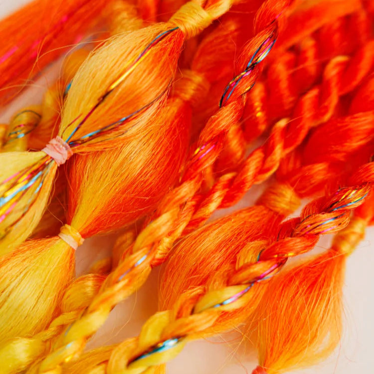 Close-up of orange and yellow braided hair extensions on a white background