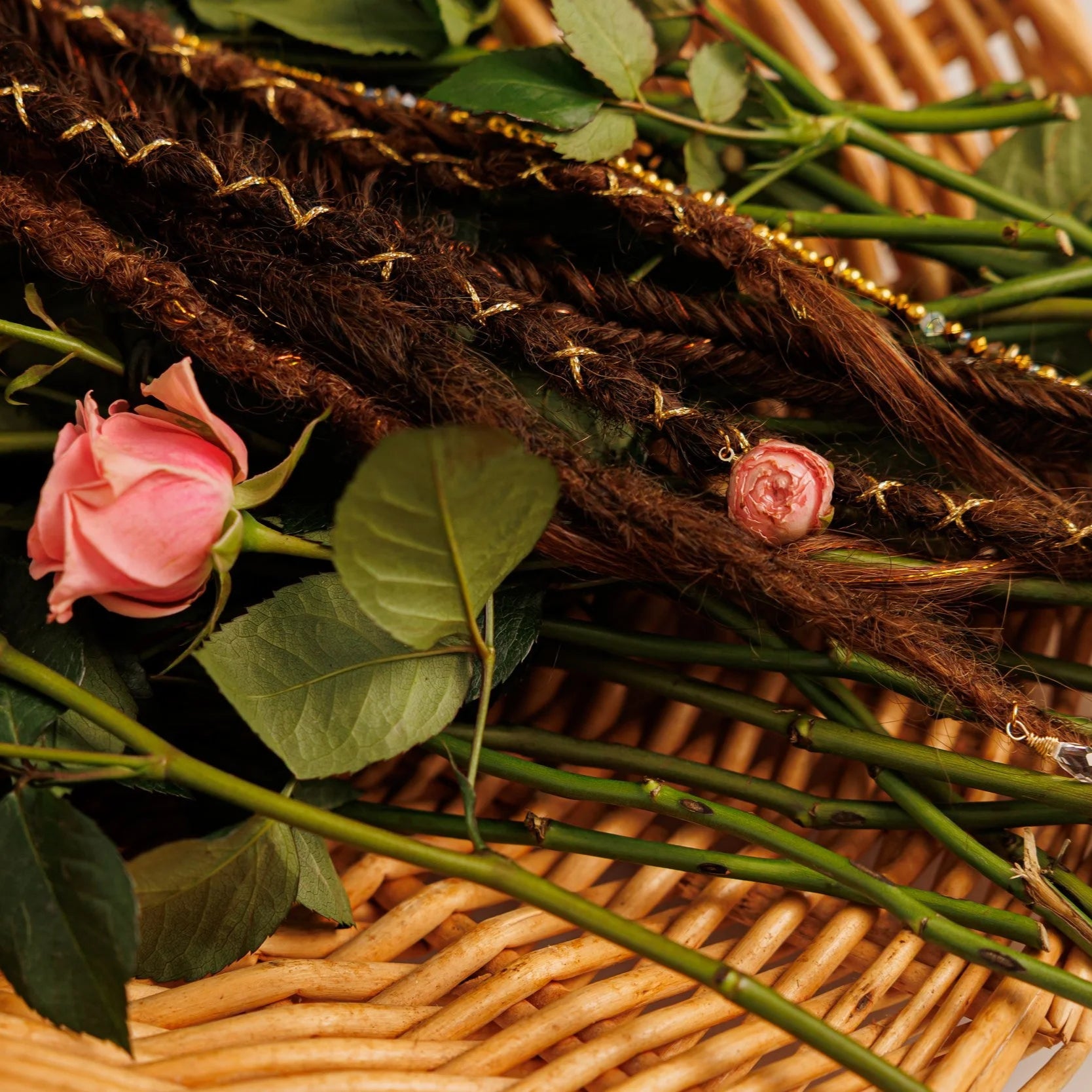 handcrafted boho hair blend of deep and medium brown shades with braided and twisted textures surrounded by rose stems