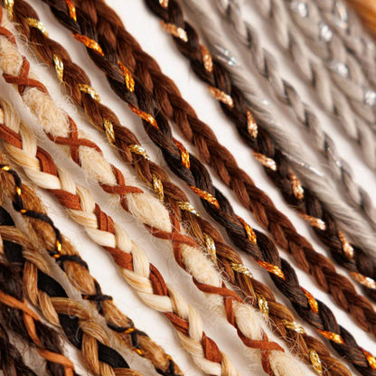 Close-up of braided hair extensions with brown, beige, and gold colors.