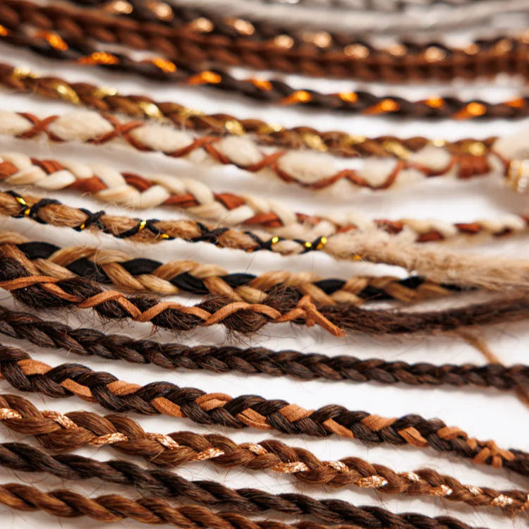 Close-up of braided hair extensions in various colors.