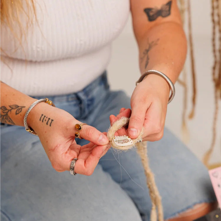 Person sitting holding a boho hair extension