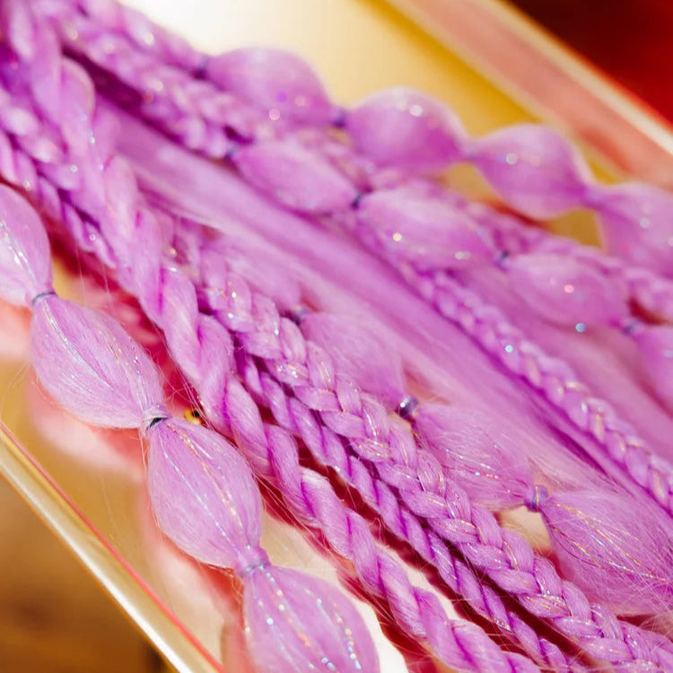 Purple braided hair extensions on a gold tray