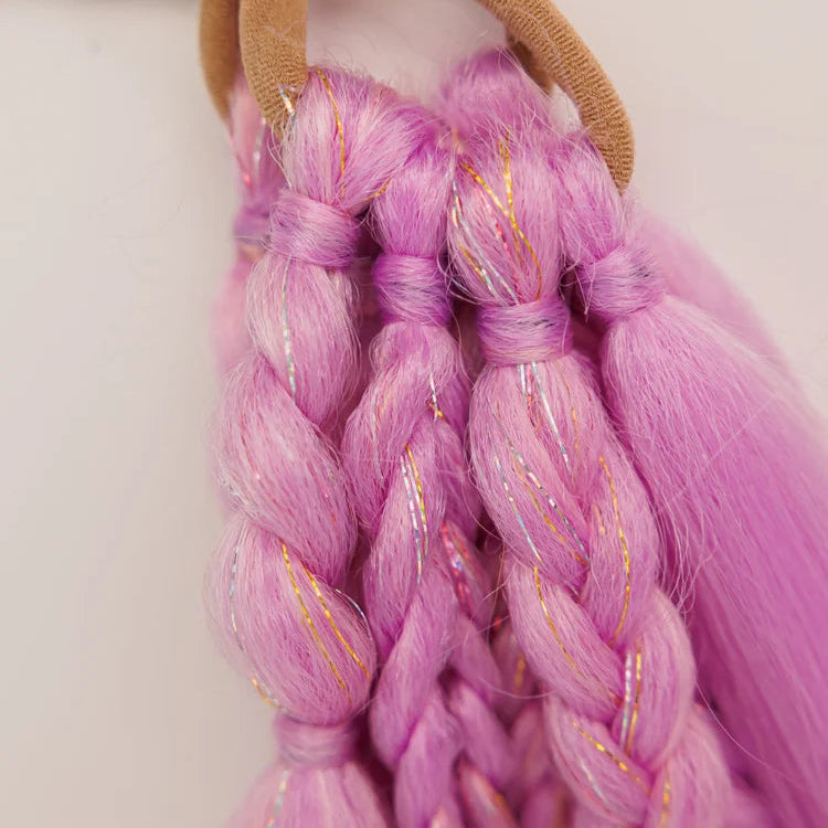 Close-up of braided pink hair extensions with a brown hair tie on a white background