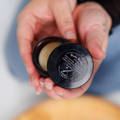 Hand holding a container of dreadlock detox