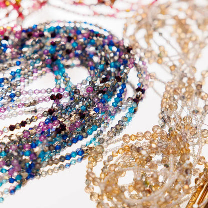 Close-up of colorful beaded necklaces on a white surface
