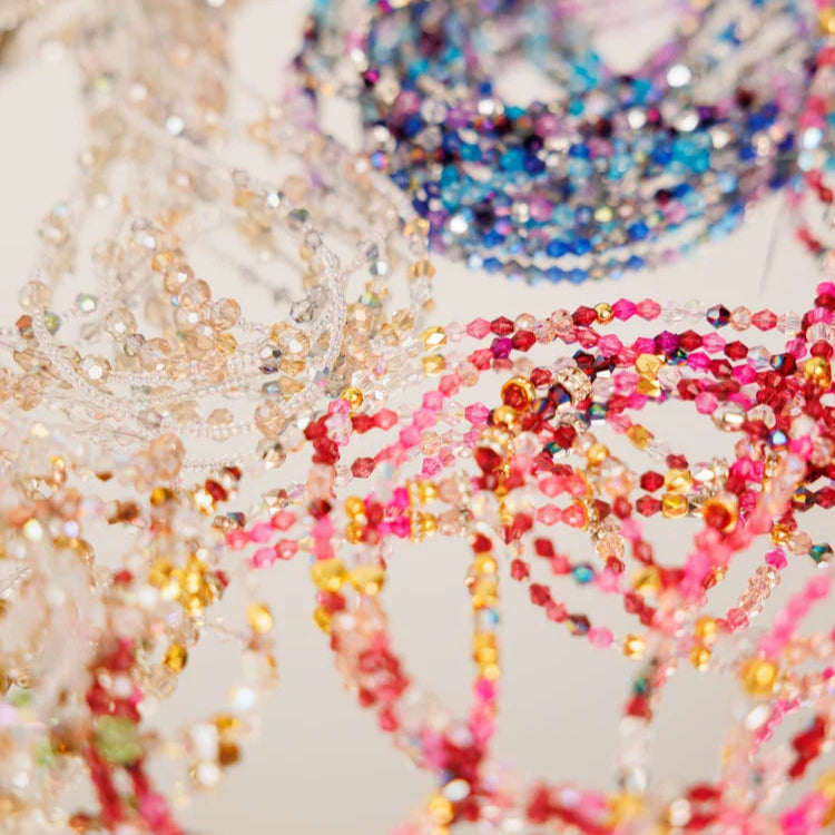 Close-up of colorful beaded chains on a light background