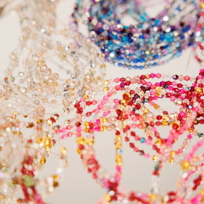 Close-up of colorful beaded chains on a light background