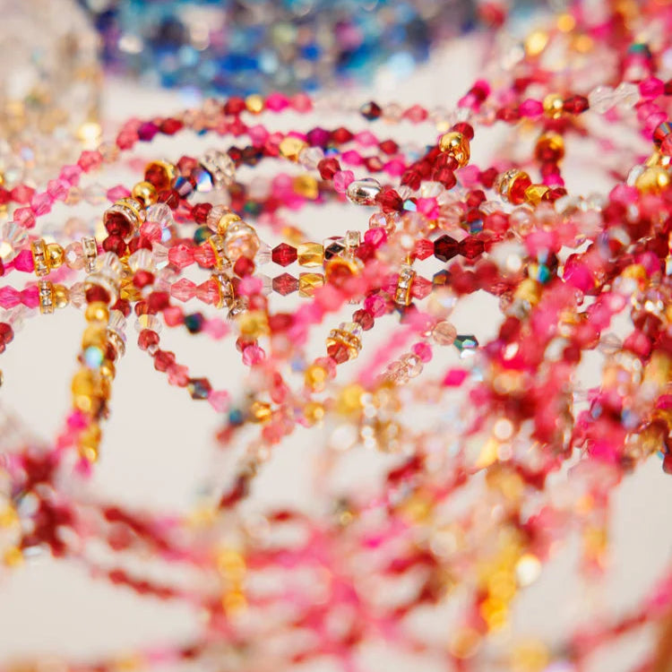 Close-up of colorful beaded strands on a blurred background