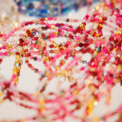 Close-up of colorful beaded strands on a blurred background