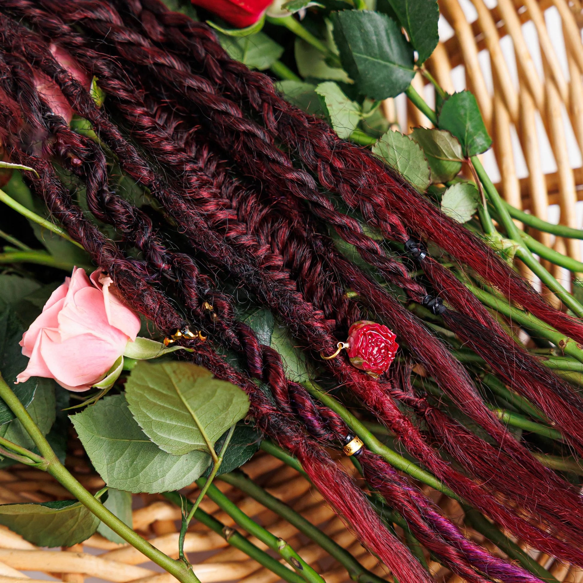close up magenta hair extensions on a basket with flowers