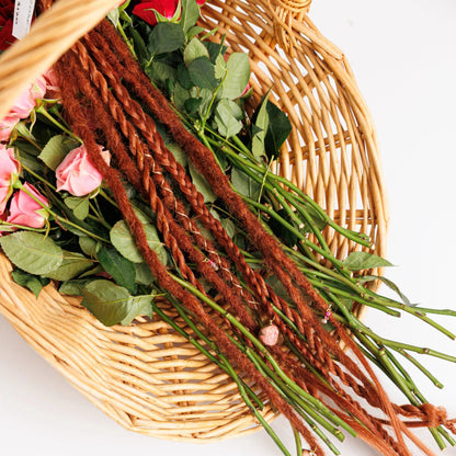 long dark natural red boho braids and dreadlocks with preserved roses in a basket