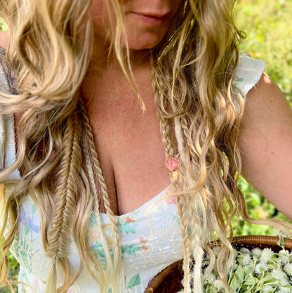 Woman with long blonde boho hair holding a basket of flowers outdoors