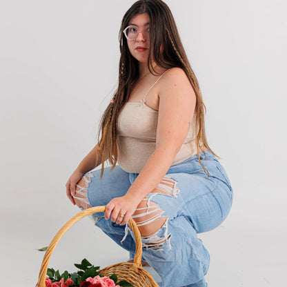 woman using the boho hair dreadlocks extension holding a basket of pink and red rose
