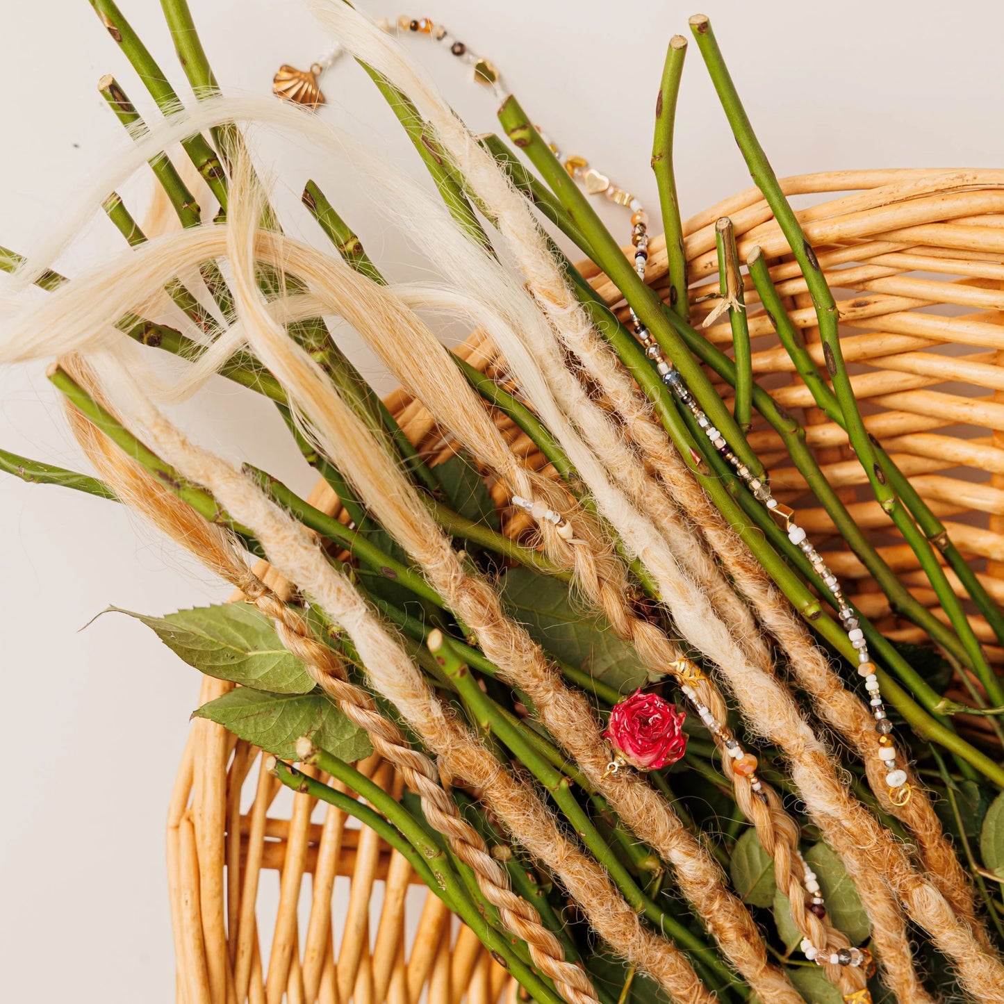 temporary blonde dreadlocks and braids in a basket of rose stems